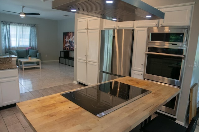 25435 Bruford Blvd, Land O Lakes, FL 34639 - kitchen featuring stainless steel appliances, butcher block counters, range hood, and white cabinets