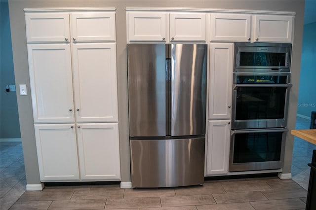 25435 Bruford Blvd, Land O Lakes, FL 34639 - kitchen with appliances with stainless steel finishes, white cabinets, and wood tiled floors