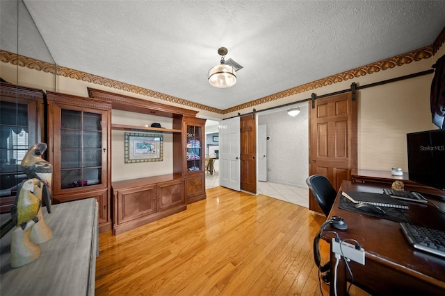 1310 Rustlewood Dr, Brandon, FL 33510 - office with a barn door, light wood-type flooring, and a textured ceiling