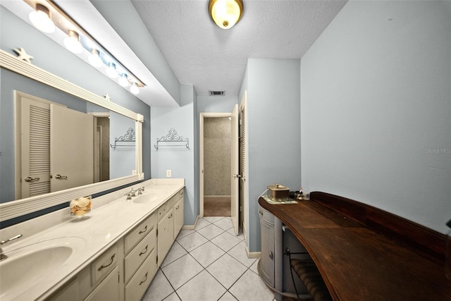 1310 Rustlewood Dr, Brandon, FL 33510 - bathroom with double vanity, a textured ceiling, and tile patterned floors