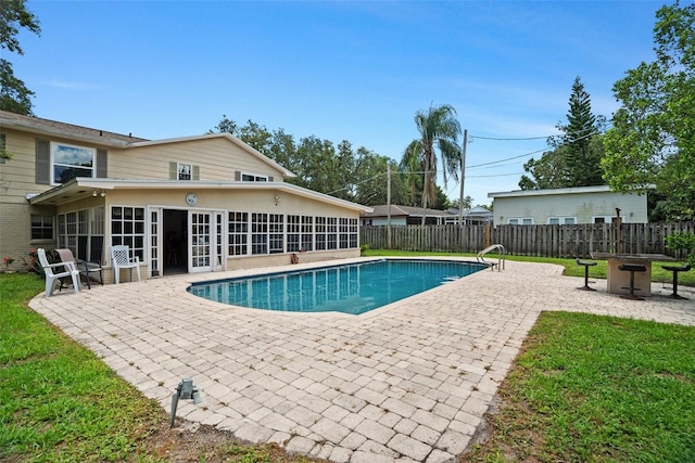 1310 Rustlewood Dr, Brandon, FL 33510 - view of pool with a sunroom, a patio area, a fenced backyard, and a fire pit