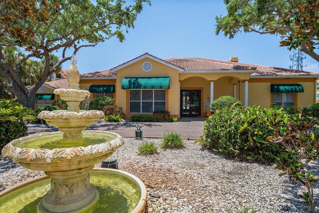 10764 70th Ave Unit 4305, Seminole, FL 33772 - mediterranean / spanish home with french doors, stucco siding, a tile roof, and a chimney