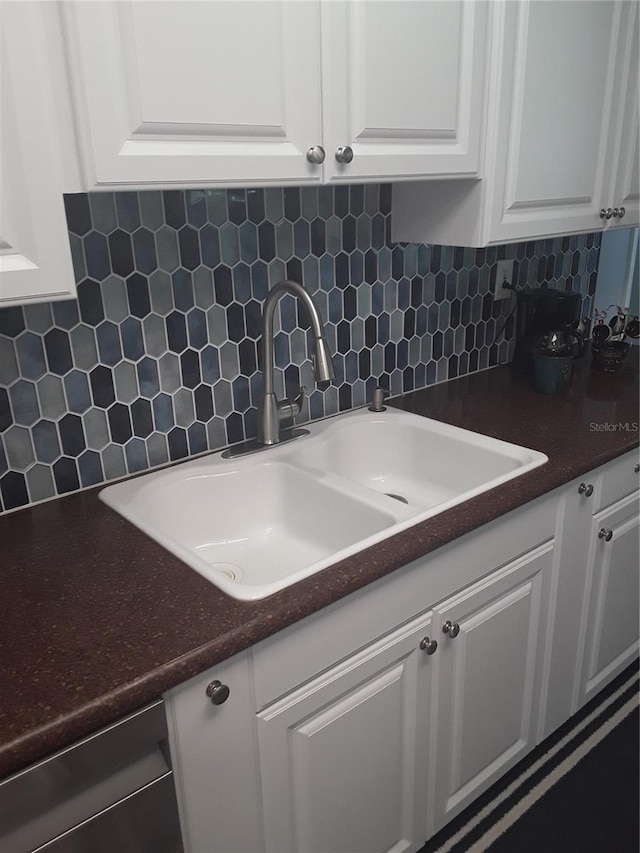 702 Cypress Pl, Sun City Center, FL 33573 - kitchen with tasteful backsplash, white cabinets, and dark countertops