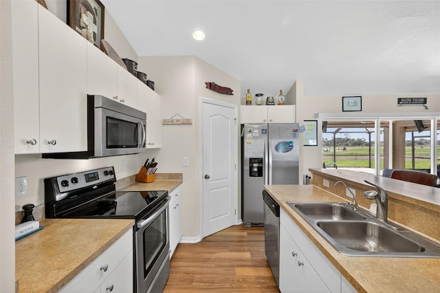 125 Paddock St, Lehigh Acres, FL 33974 - kitchen with stainless steel appliances, light wood-type flooring, white cabinetry, recessed lighting, and light countertops