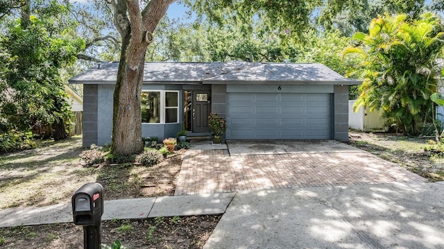 6 Harbor Cove St, Safety Harbor, FL 34695 - view of front facade with decorative driveway, a garage, and stucco siding