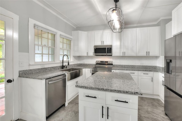 720 Woodward St, Lakeland, FL 33803 - kitchen with appliances with stainless steel finishes, healthy amount of natural light, a kitchen island, tasteful backsplash, and ornamental molding