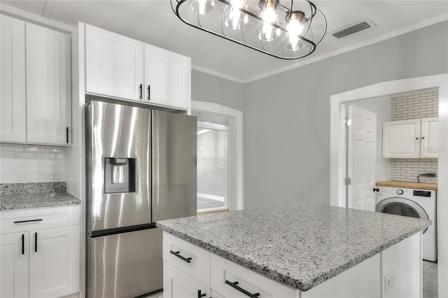 720 Woodward St, Lakeland, FL 33803 - kitchen with stainless steel fridge with ice dispenser, washer / clothes dryer, tasteful backsplash, ornamental molding, and light stone countertops