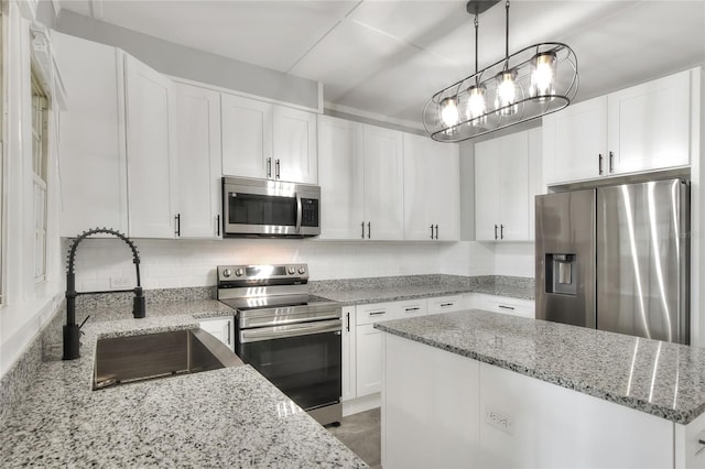 720 Woodward St, Lakeland, FL 33803 - kitchen featuring stainless steel appliances, white cabinets, a center island, light stone countertops, and backsplash