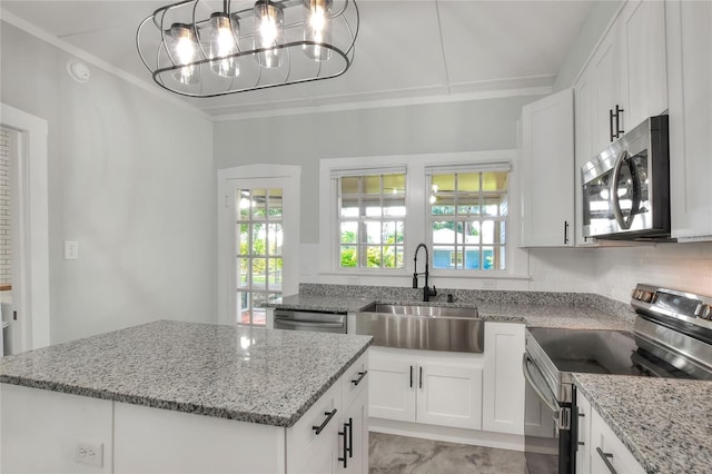 720 Woodward St, Lakeland, FL 33803 - kitchen with appliances with stainless steel finishes, a center island, crown molding, light stone counters, and white cabinets