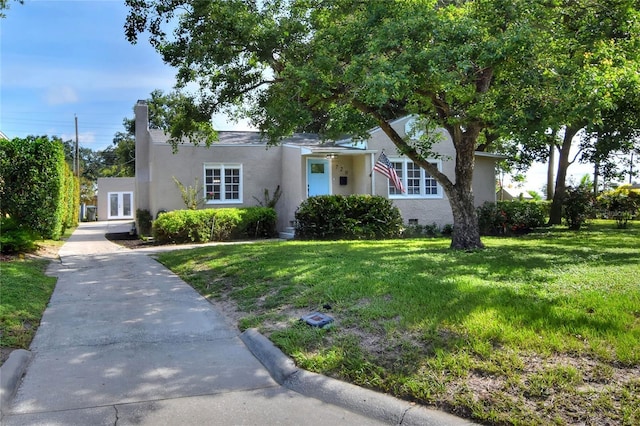 720 Woodward St, Lakeland, FL 33803 - view of front of property with stucco siding, a front yard, driveway, and french doors