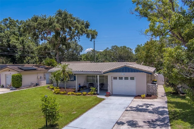 2123 Indigo Dr, Clearwater, FL 33763 - ranch-style house with a garage, a front lawn, a tile roof, stucco siding, and driveway