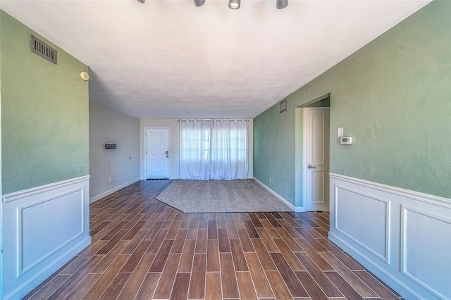 2123 Indigo Dr, Clearwater, FL 33763 - unfurnished room featuring dark wood-style flooring, a textured wall, and a wainscoted wall