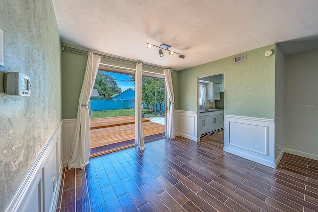 2123 Indigo Dr, Clearwater, FL 33763 - empty room featuring dark wood finished floors, a wainscoted wall, a textured wall, a smoke detector, and a decorative wall