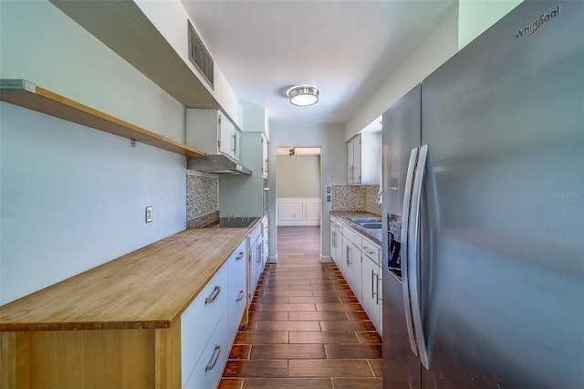 2123 Indigo Dr, Clearwater, FL 33763 - kitchen featuring stainless steel refrigerator with ice dispenser, black electric cooktop, decorative backsplash, white cabinetry, and under cabinet range hood