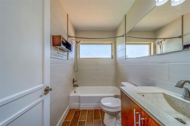 2123 Indigo Dr, Clearwater, FL 33763 - bathroom featuring tile walls, vanity, washtub / shower combination, and wood finished floors