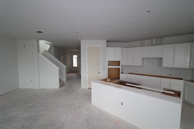 640 Allora Ave, Nokomis, FL 34275 - kitchen featuring a center island, concrete floors, and white cabinets