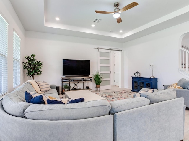 6057 Marsh Trail Dr, Odessa, FL 33556 - living area with a barn door, ceiling fan, arched walkways, a raised ceiling, and recessed lighting