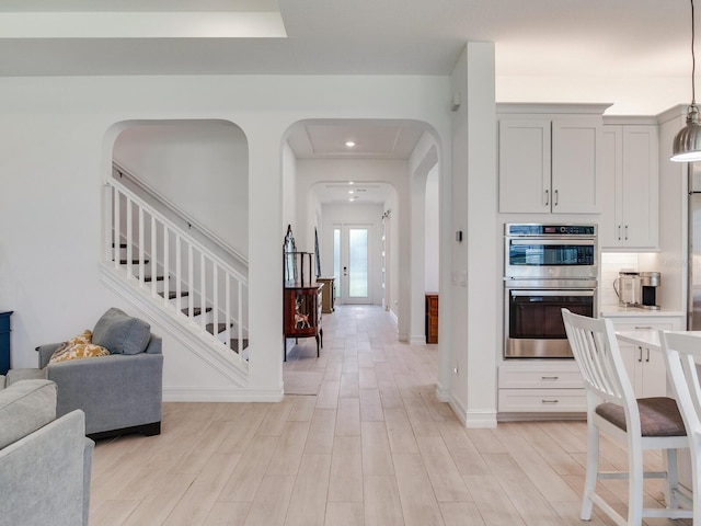6057 Marsh Trail Dr, Odessa, FL 33556 - kitchen with double oven, arched walkways, open floor plan, light wood-style floors, and recessed lighting