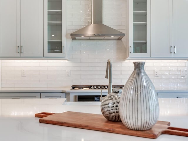 6057 Marsh Trail Dr, Odessa, FL 33556 - kitchen view of wall chimney range hood, decorative backsplash, glass insert cabinets, and light countertops
