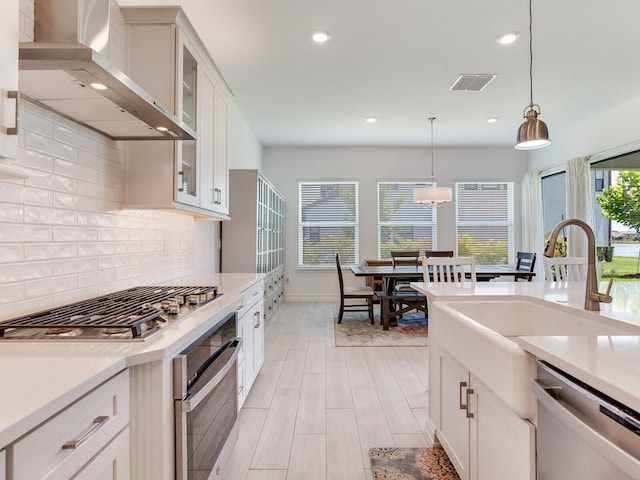 6057 Marsh Trail Dr, Odessa, FL 33556 - kitchen with appliances with stainless steel finishes, wall chimney range hood, recessed lighting, decorative backsplash, and pendant lighting