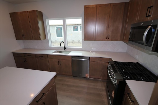 699 Allora Ave, Nokomis, FL 34275 - kitchen with appliances with stainless steel finishes, wood finished floors, tasteful backsplash, light countertops, and brown cabinetry