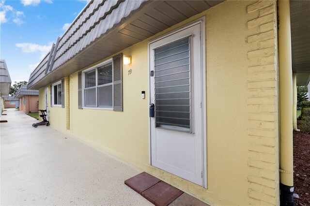 201 Bedford St Unit 79, Sun City Center, FL 33573 - view of exterior entry with stucco siding and mansard roof