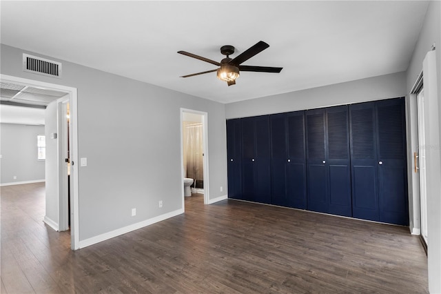 201 Bedford St Unit 79, Sun City Center, FL 33573 - unfurnished bedroom featuring dark wood-type flooring, ensuite bath, a closet, and ceiling fan