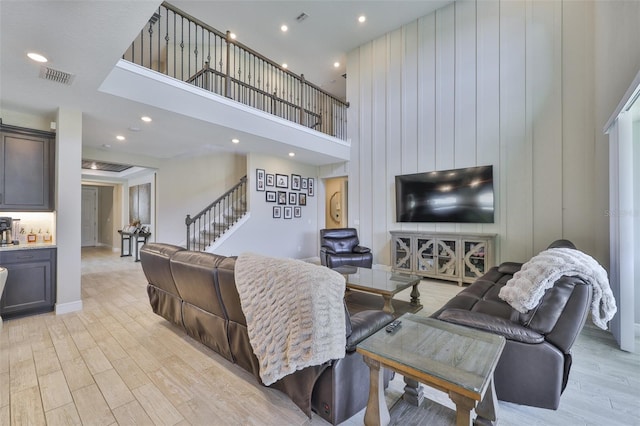 2866 Quail Crest Ct, Valrico, FL 33594 - living room with stairs, light wood-style floors, a high ceiling, and recessed lighting