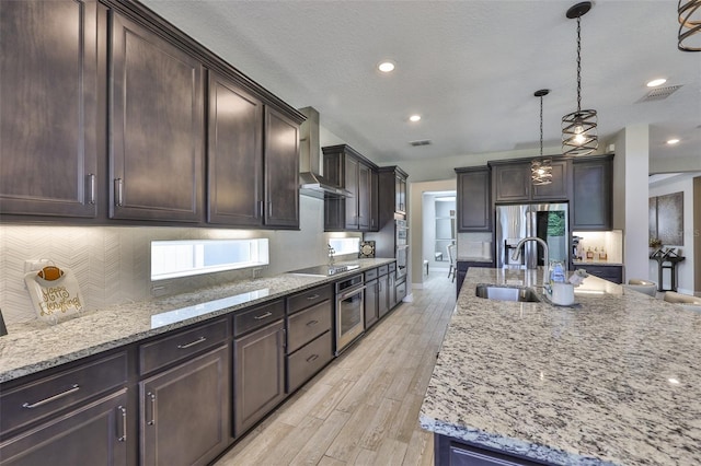2866 Quail Crest Ct, Valrico, FL 33594 - kitchen with stainless steel fridge with ice dispenser, wall chimney exhaust hood, black electric stovetop, light stone countertops, and recessed lighting