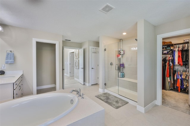 2866 Quail Crest Ct, Valrico, FL 33594 - full bath featuring a shower stall, a bath, a spacious closet, vanity, and tile patterned floors