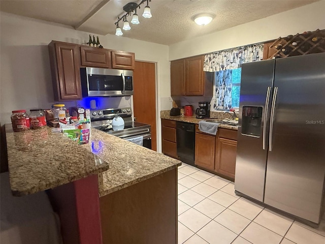 612 NW 9th Cir, Williston, FL 32696 - kitchen with appliances with stainless steel finishes, a peninsula, light tile patterned flooring, light stone counters, and a textured ceiling