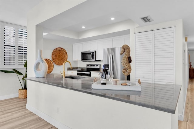 602 Lime Ave Unit 102, Clearwater, FL 33756 - kitchen featuring appliances with stainless steel finishes, light wood-type flooring, white cabinetry, and recessed lighting