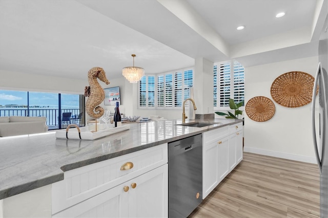 602 Lime Ave Unit 102, Clearwater, FL 33756 - kitchen with stainless steel appliances, stone countertops, white cabinetry, light wood-style floors, and hanging light fixtures