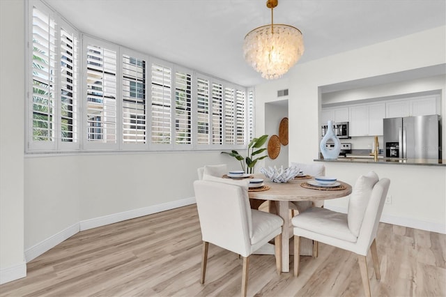 602 Lime Ave Unit 102, Clearwater, FL 33756 - dining area with a chandelier and light wood-style flooring