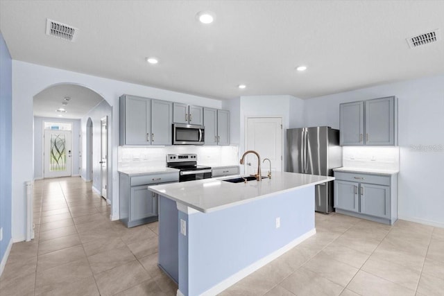 33369 Hamilton Hill Ln, Wesley Chapel, FL 33545 - kitchen featuring appliances with stainless steel finishes, arched walkways, tasteful backsplash, gray cabinets, and recessed lighting