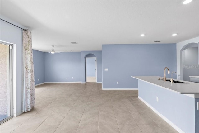 33369 Hamilton Hill Ln, Wesley Chapel, FL 33545 - unfurnished living room featuring a ceiling fan, arched walkways, recessed lighting, and light tile patterned floors