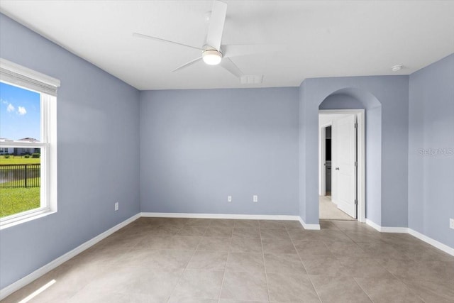 33369 Hamilton Hill Ln, Wesley Chapel, FL 33545 - spare room featuring a ceiling fan, arched walkways, a smoke detector, and light tile patterned floors