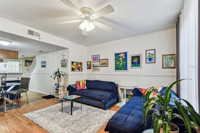 3335 Fox Hunt Dr, Palm Harbor, FL 34683 - living area with a textured ceiling, stairs, wood finished floors, and a ceiling fan