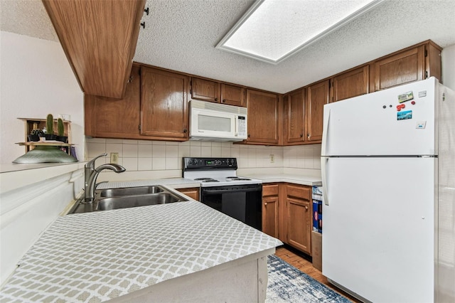 3335 Fox Hunt Dr, Palm Harbor, FL 34683 - kitchen with white appliances, light countertops, tasteful backsplash, brown cabinets, and a textured ceiling