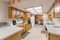5781 S Utopia Ter, Inverness, FL 34452 - kitchen with brown cabinets, extractor fan, and light countertops