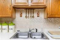 5781 S Utopia Ter, Inverness, FL 34452 - kitchen with brown cabinets, light countertops, and backsplash
