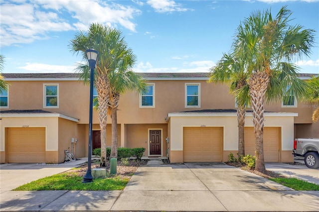 12710 Buffalo Run Dr, Gibsonton, FL 33534 - townhome / multi-family property with stucco siding, an attached garage, and driveway