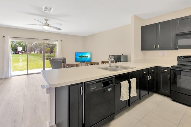 12710 Buffalo Run Dr, Gibsonton, FL 33534 - kitchen with black appliances, a peninsula, light countertops, dark cabinets, and open floor plan