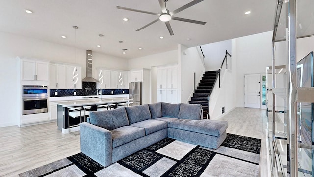 5307 Wishing Arch Dr, Apollo Beach, FL 33572 - living room featuring stairway, light wood-style floors, ceiling fan, and recessed lighting