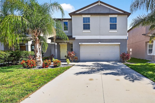 13324 Willow Bluestar Loop, Riverview, FL 33579 - view of front of house with stucco siding, driveway, a garage, and a front lawn