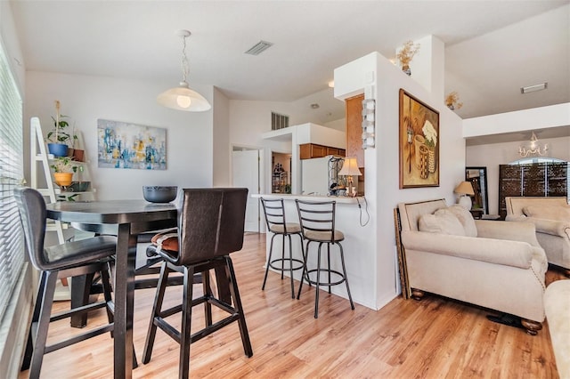 7046 Frascati Loop, Wesley Chapel, FL 33544 - dining space with light wood-style floors and a chandelier