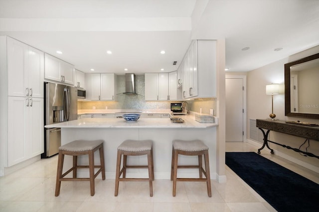 4 Belleview Blvd Unit 305, Belleair, FL 33756 - kitchen with stainless steel appliances, wall chimney exhaust hood, a peninsula, backsplash, and recessed lighting