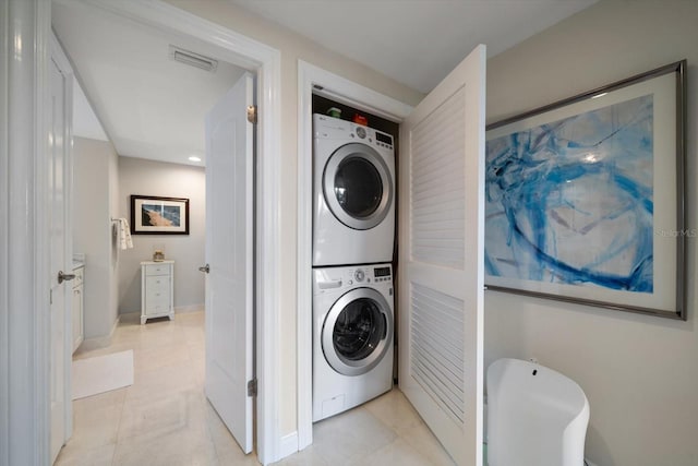 4 Belleview Blvd Unit 305, Belleair, FL 33756 - laundry area featuring stacked washer and clothes dryer and light tile patterned flooring