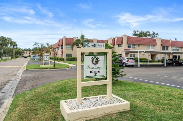10033 64th Ave N Unit 4, Saint Petersburg, FL 33708 - community / neighborhood sign with uncovered parking and a lawn