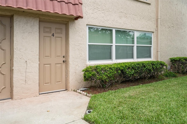 10033 64th Ave N Unit 4, Saint Petersburg, FL 33708 - property entrance featuring stucco siding and a yard